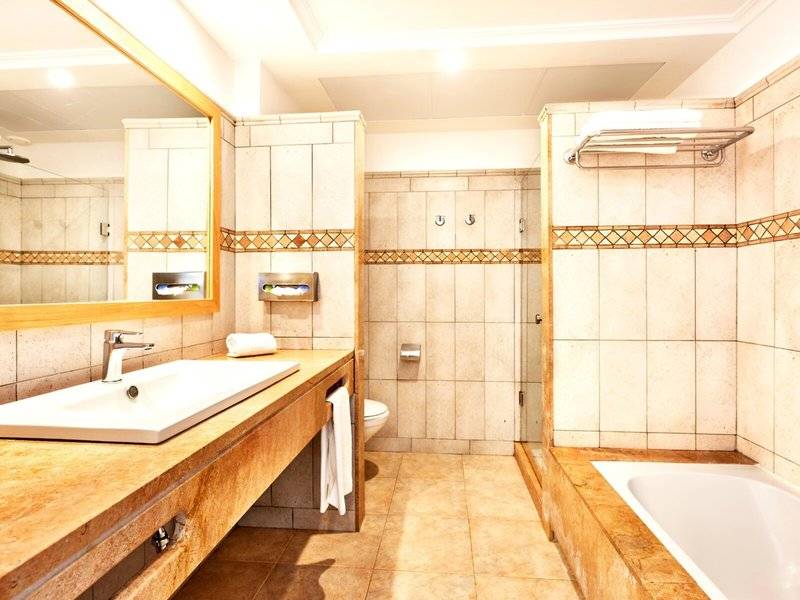 Badezimmer im Punta Prima Resort & Spa mit Waschbecken, Spiegel und Dusche