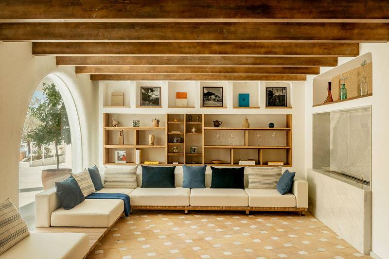 Inneneinrichtung des Villa Le Blanc Gran Melia Hotels mit Holzbalkendecke, Wandregal und Sofas.