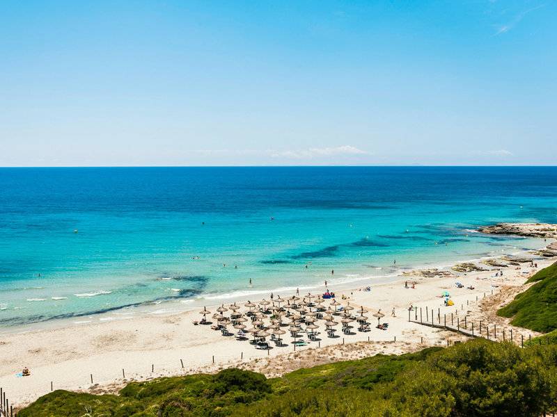 Aussicht auf den Strand des Globales Lord Nelson Hotels mit vielen Sonnenschirmen und Gästen.