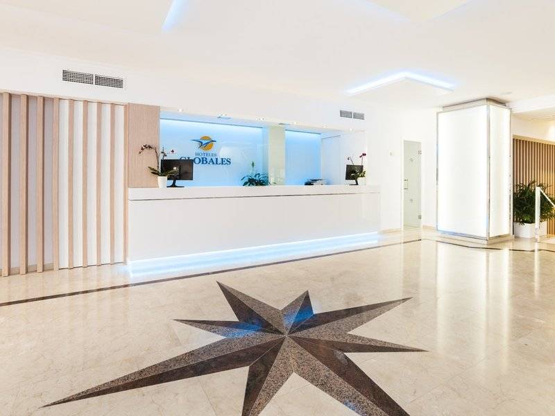 Empfangsbereich des Globales Lord Nelson Hotels mit Logo, Sternenmuster im Boden und modernen Möbeln