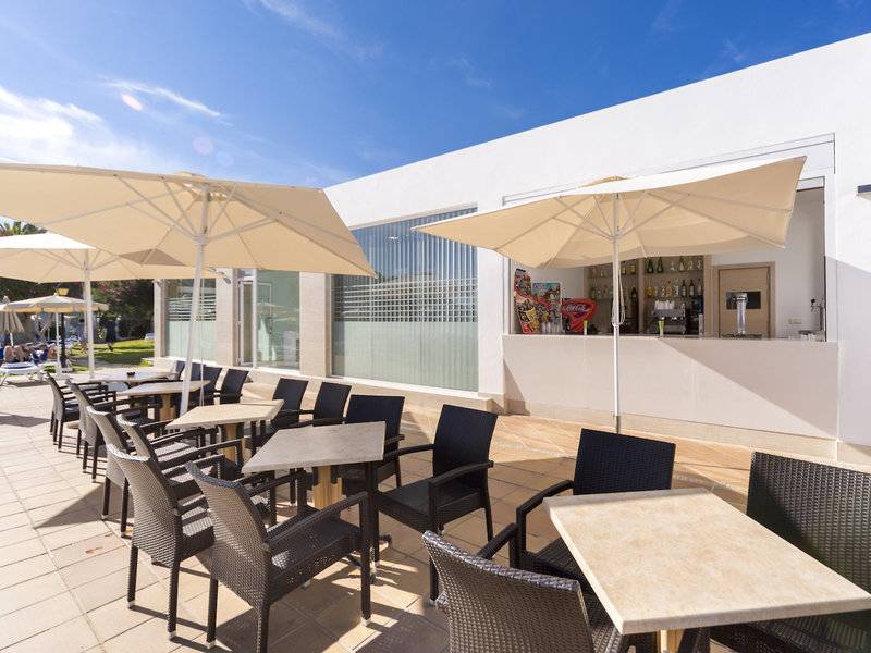 Terrasse des Globales Lord Nelson Hotels mit Tischen und Stühlen unter Sonnenschirmen