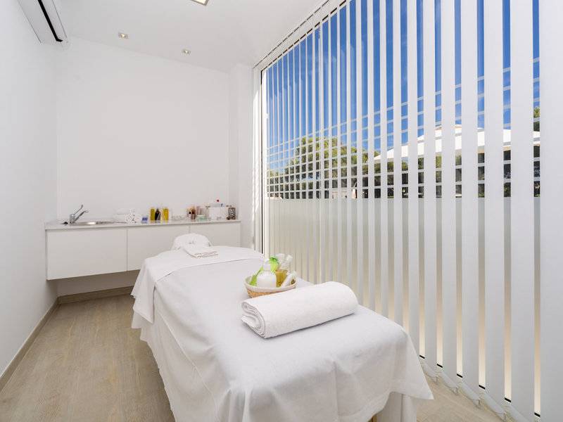 Massageraum im Globales Lord Nelson Hotel mit Behandlungstisch und Blick nach draußen
