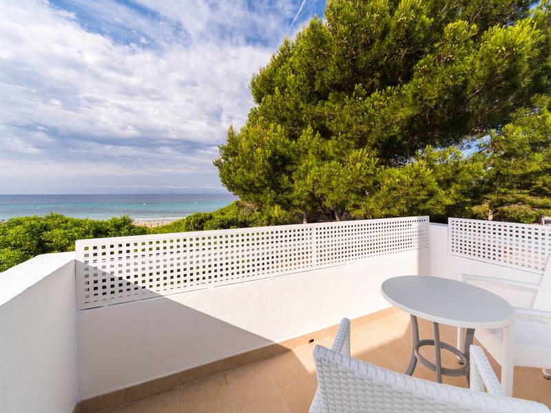 Balkon des Globales Lord Nelson Hotels mit Blick auf das Meer und grünen Bäumen.