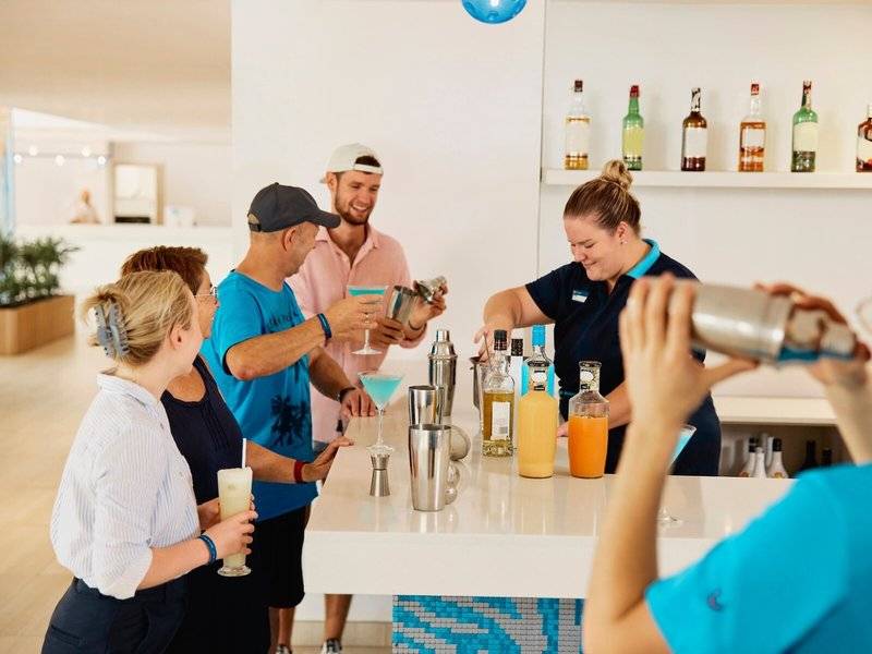 Gäste lernen am Cocktailstand im Hotel Victoria Menorca Cocktails zuzubereiten