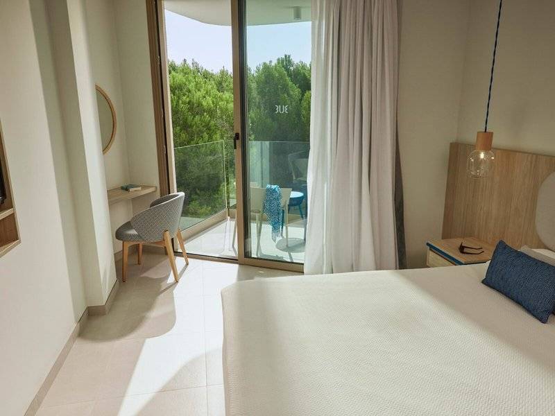 Innenansicht eines Hotelzimmers im Victoria Menorca mit Blick auf die Terrasse und die Außenmöbel.