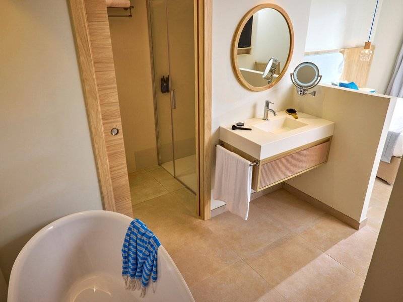 Victoria Menorca Hotel Badezimmer mit Badewanne, Dusche, Waschbecken und Spiegel.