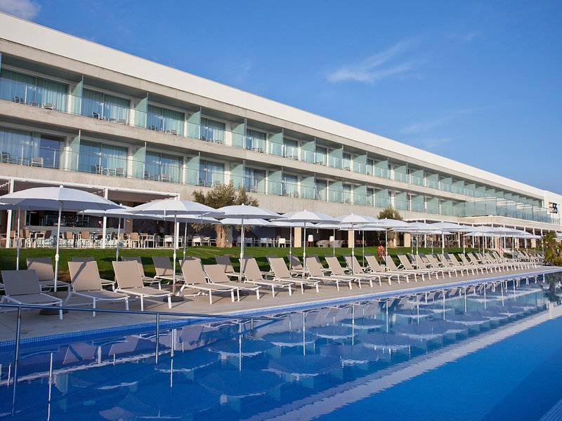 Außenbereich des Seth 55 Santo Tomás Hotels mit Swimmingpool, Sonnenliegen und Sonnenschirmen.