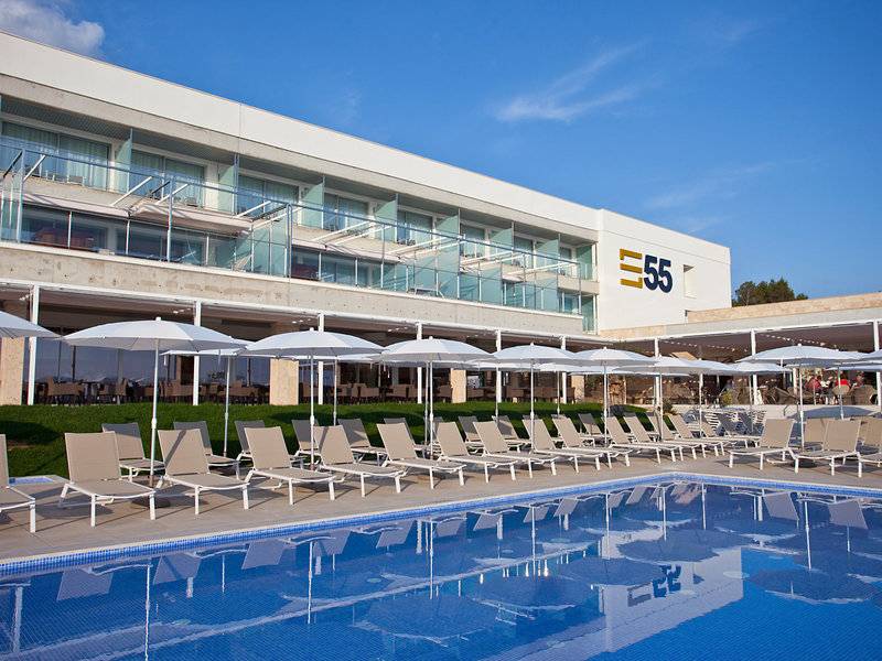 Poolbereich des Seth 55 Santo Tomás Hotels mit weißen Sonnenschirmen und Liegen.