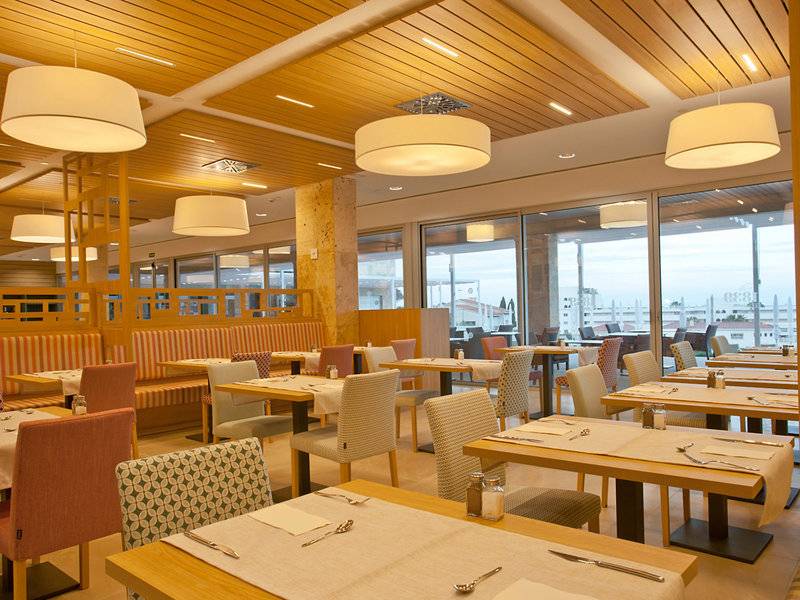 Innenansicht des Restaurants im Seth 55 Santo Tomás Hotel mit holzvertäfelter Decke und großen Fenstern.
