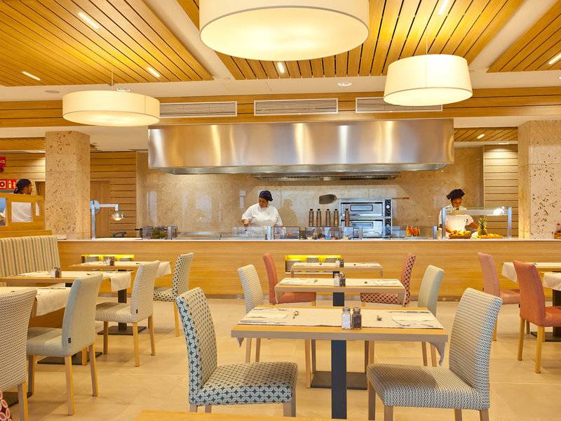 Innenansicht des Restaurants Seth 55 Santo Tomás mit Küchenbereich und Esstischen.