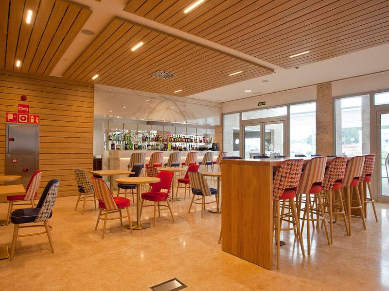 Loungebereich des Seth 55 Santo Tomás Hotels mit Holzelementen, Tischen und Stühlen.