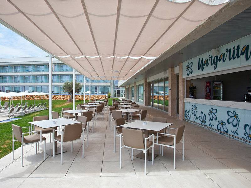 Terrasse des Seth 55 Santo Tomás Hotels mit Tischen, Stühlen und Margarita Bar.
