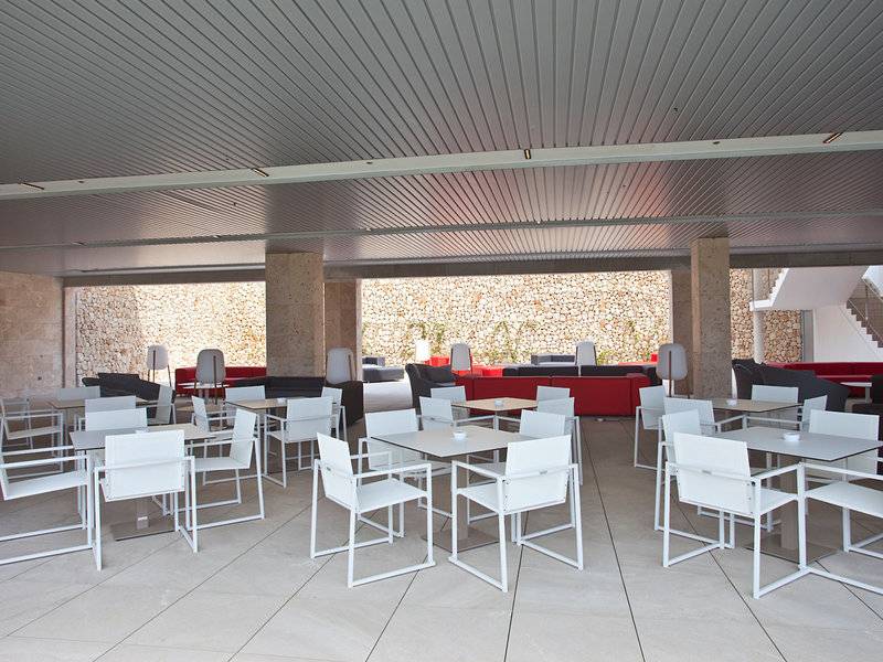 Lounge-Bereich des Seth 55 Santo Tomás Hotels mit weißen Tischen und Stühlen.
