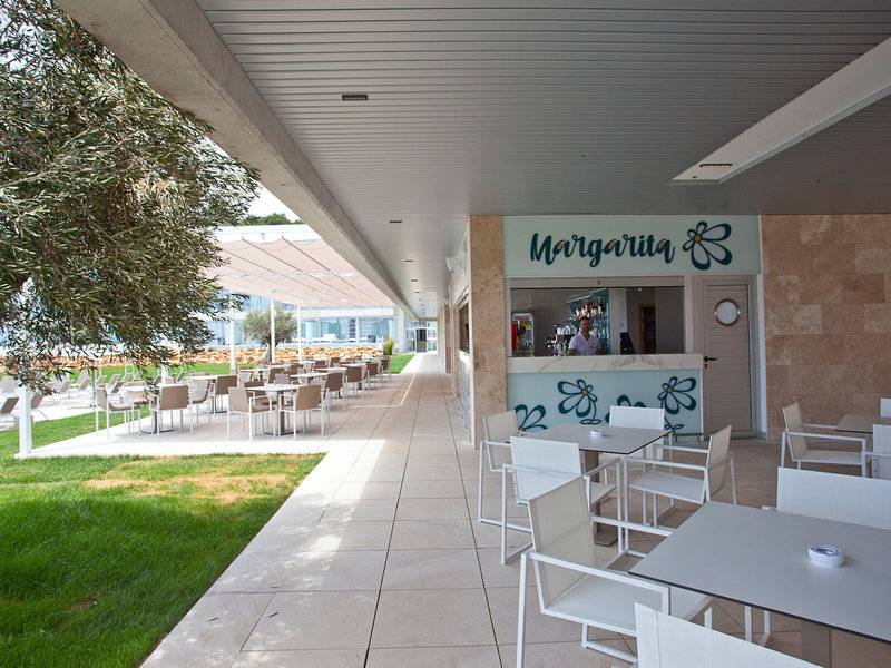 Außenbereich des Seth 55 Santo Tomás Hotels mit der Margarita Bar, Tischen und Stühlen