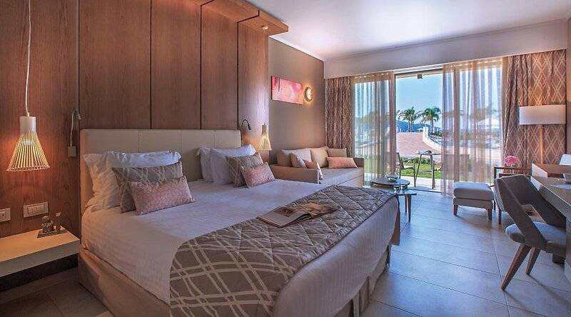 Luxuriöses Hotelzimmer im Miraggio Thermal Spa Resort mit Bett, Sofa, Schreibtisch und Meerblick.