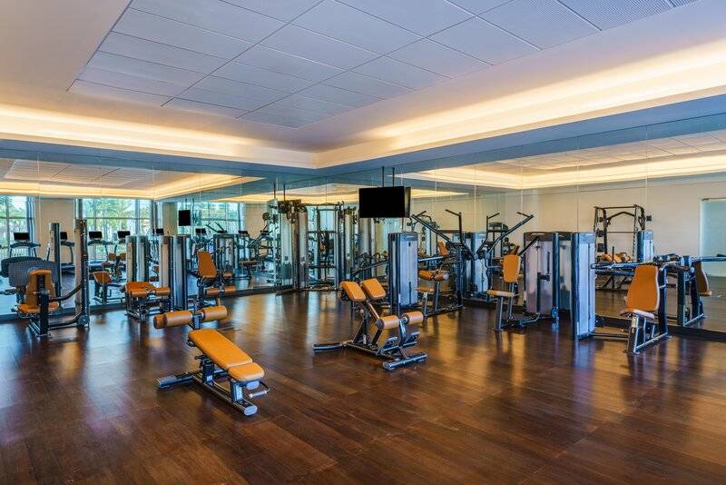 Fitnessstudio im Rixos Marina Abu Dhabi mit modernen Geräten und Panoramafenstern.