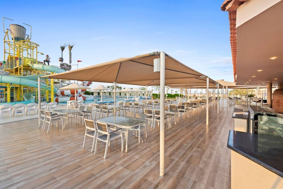 Terrasse des Pickalbatros Aqua Park Resorts mit Tischen, Stühlen und Sonnenschirmen