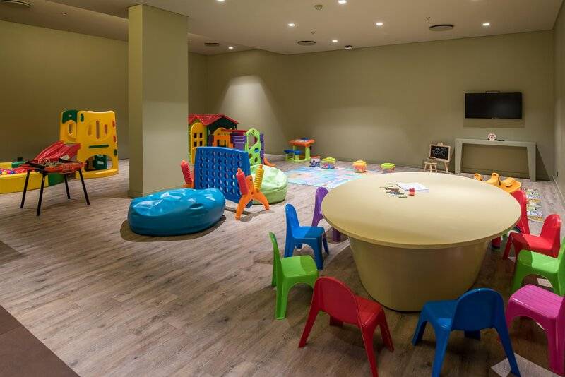 Kinderspielzimmer im Saccharum Hotel mit bunten Spielsachen und einem Tisch.