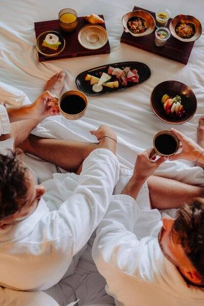 Frühstück im Bett im Saccharum Hotel mit verschiedenen Gerichten und Getränken.