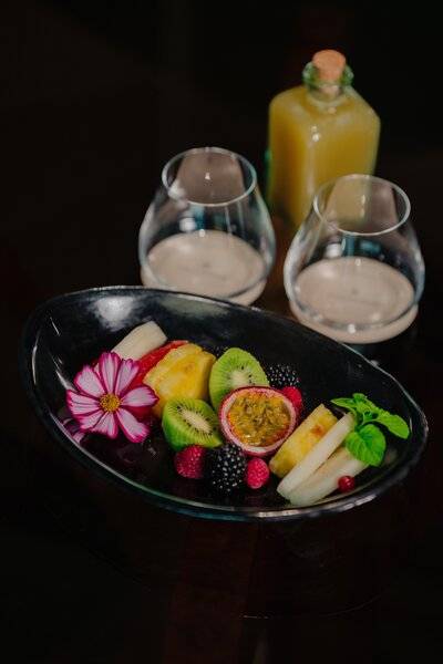 Obstplatte mit verschiedenen Früchten und zwei Gläsern im Saccharum Hotel.