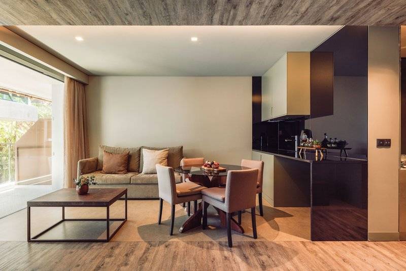 Wohnzimmer des Saccharum Hotels mit einem Tisch, Stühlen und einem Sofa.