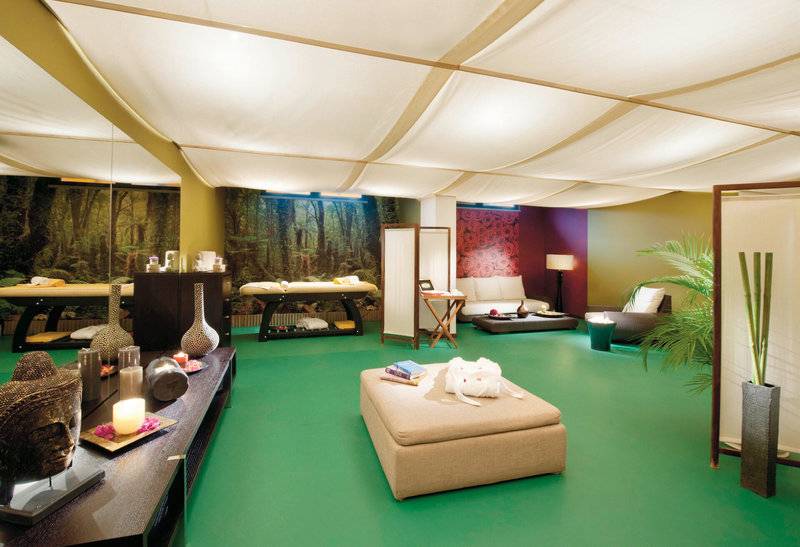 Wellnessbereich des Madeira Panorâmico Hotels mit grünem Boden, Massagetischen und Pflanzen.