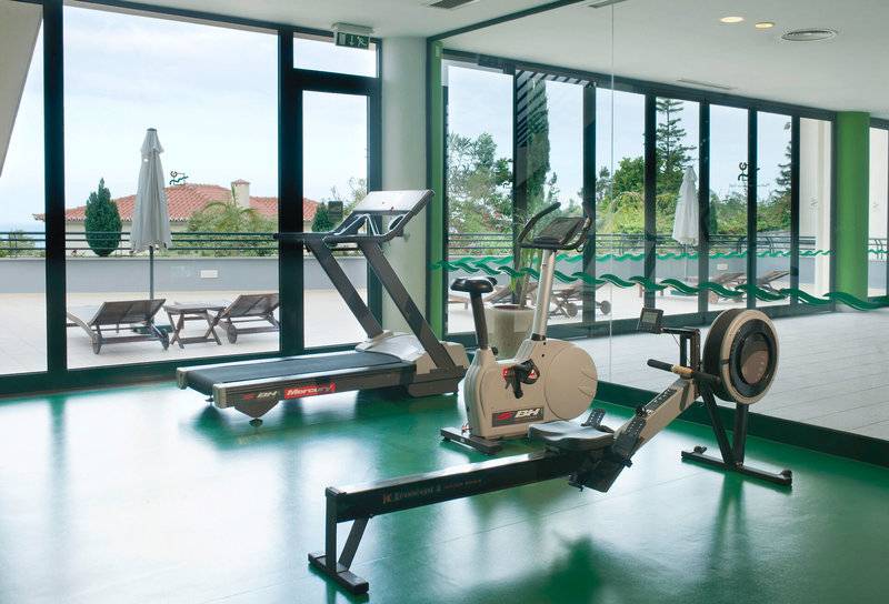 Fitnessstudio im Madeira Panorâmico Hotel mit Geräten und großen Fenstern
