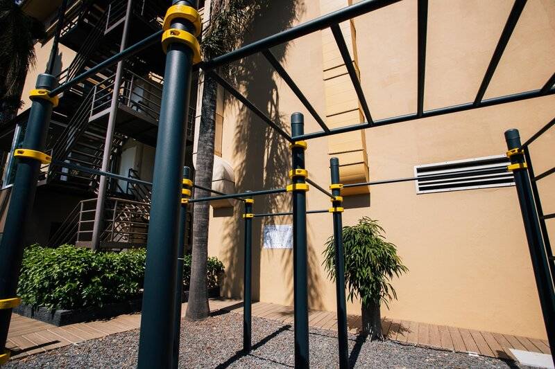 Außen Fitnessgeräte im Views Oasis Hotel, umgeben von Pflanzen und einer Treppe.
