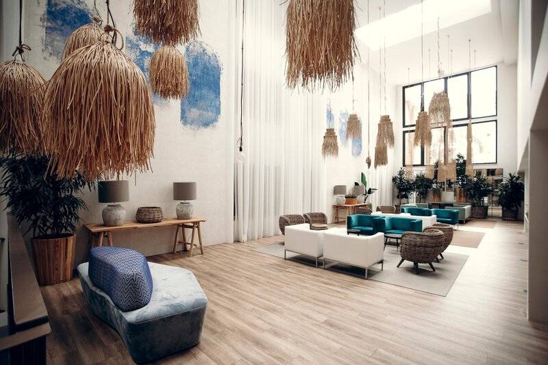 Lobby des Views Oasis Hotels mit Holzboden, weißen Wänden und blauen Möbeln.