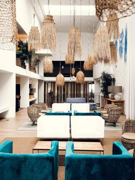 Lobby des Views Oasis Hotels mit weißen Möbeln, blauen Kissen und rustikalen Hängelampen.