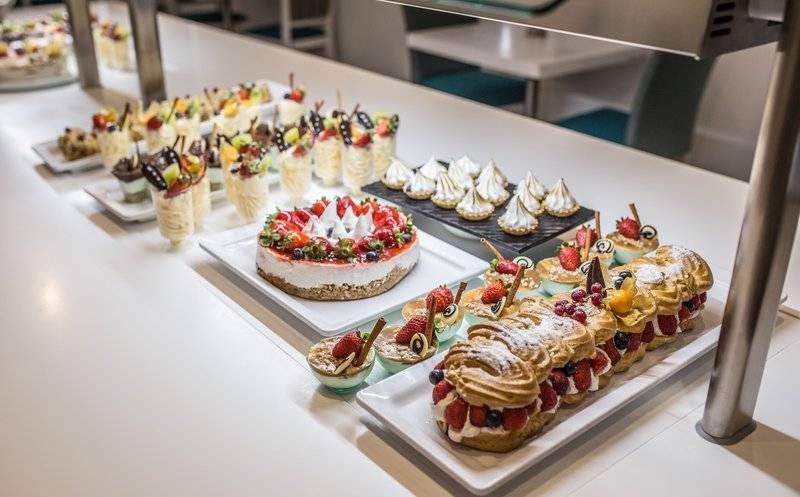 Desserts-Buffet im The Views Oasis Hotel mit verschiedenen Kuchen, Eis und Früchten.