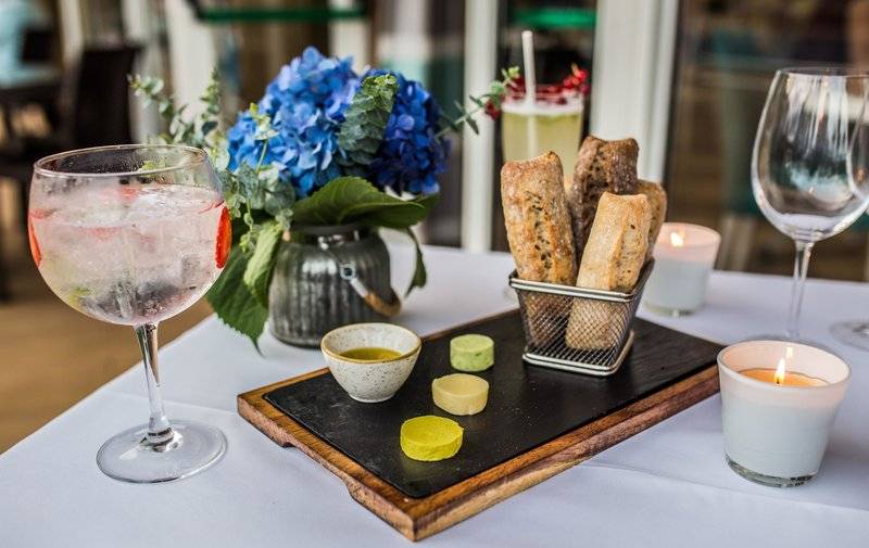 Tisch mit Getraenke, Brot, Blumen und Kerzen bei The Views Oasis Hotel