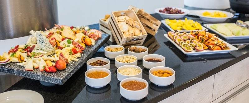 Buffettisch mit Käse, Obst und Getränken im The Views Oasis Hotel.