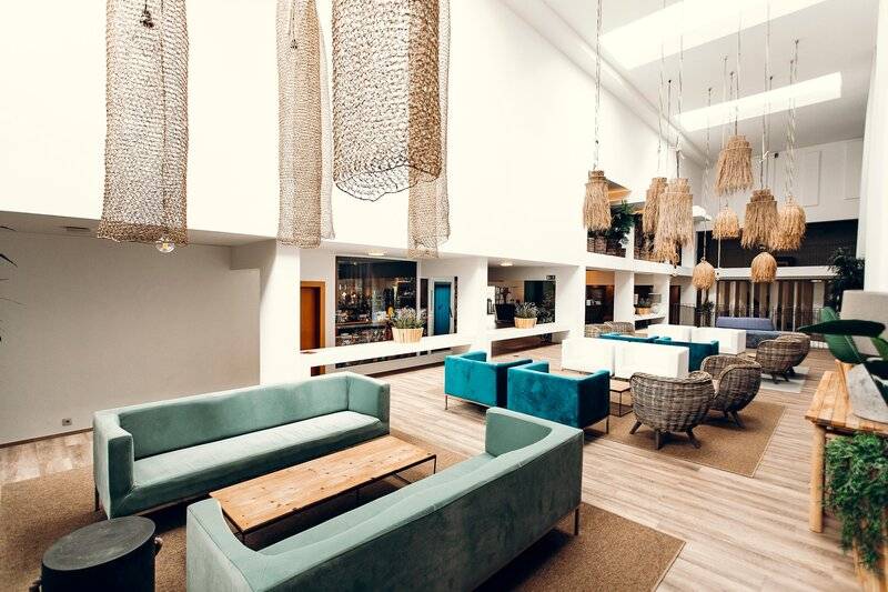 Lobby des Views Oasis Hotels mit modernen Möbeln, Holzböden und hängenden Lampen.
