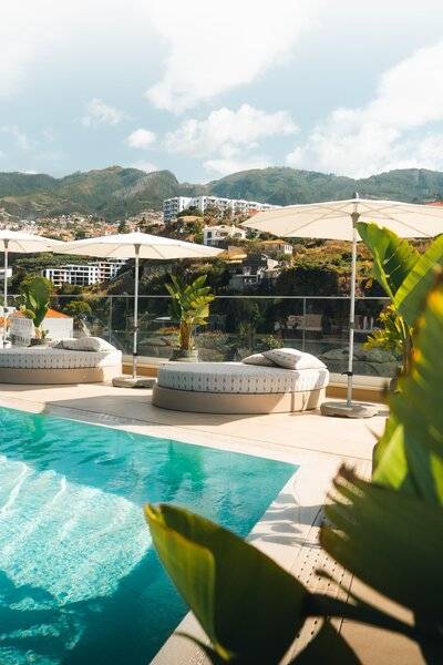 Pool-Terrasse im Views Baia Hotel mit Sonnenliegen und Schirmen.