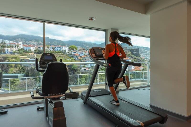 Frau im Fitnessraum des Hotels The Views Baia, die auf einem Laufband läuft