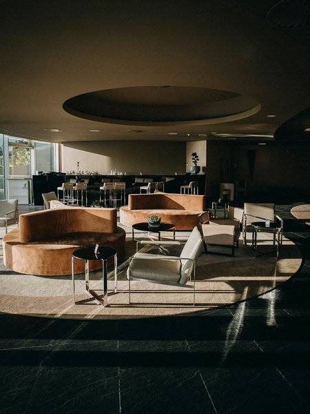 Loungebereich im The Views Baia Hotel mit modernen Möbeln und Sonnenlicht.