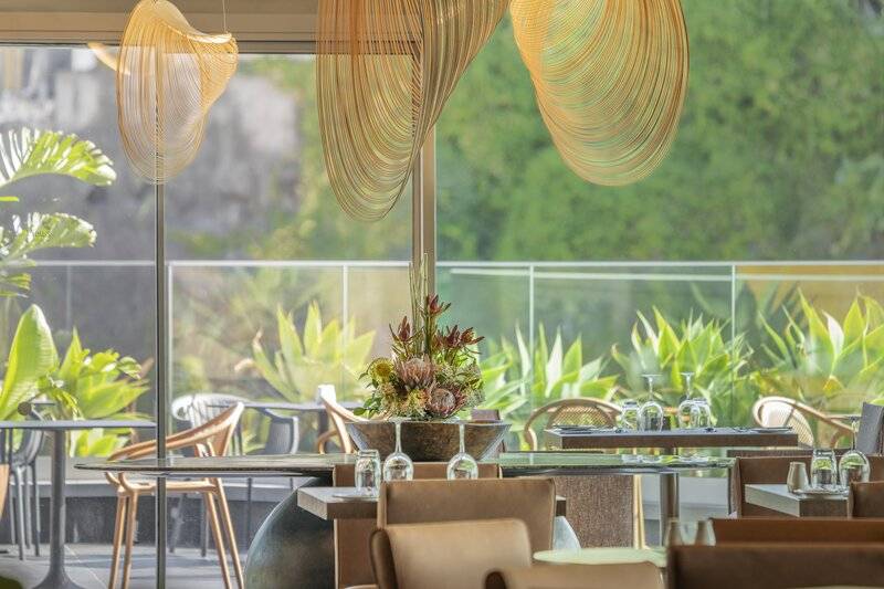 Innenansicht des Restaurants The Views Baia mit modernen Möbeln und blumigem Dekor.