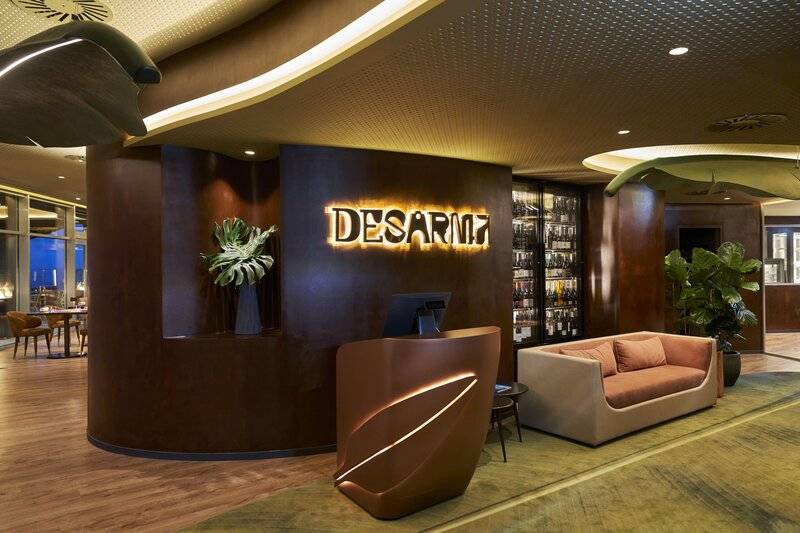 Empfangsbereich des Desarmo Hotels mit modernem Design und einem großen Schild.