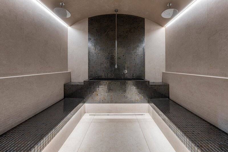 Innenbereich einer Sauna im Hotel The Views Baia mit schwarzen und weißen Fliesen.
