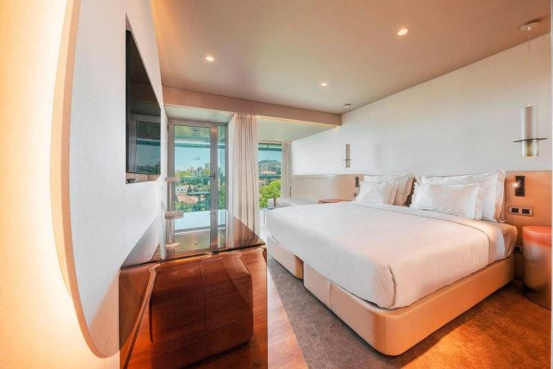 Schlafzimmer im Views Baia Hotel mit großem Bett und Stadtblick.