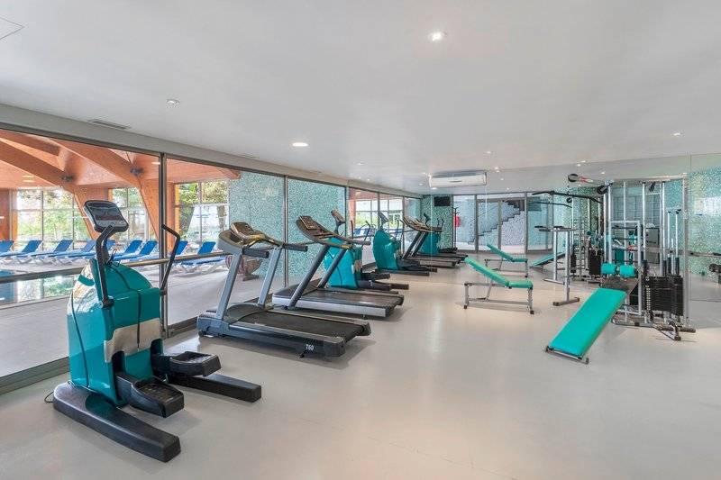 Fitnessraum im Royal Savoy Hotel mit moderner Trainingsgeräten und blauen Liegebänken.