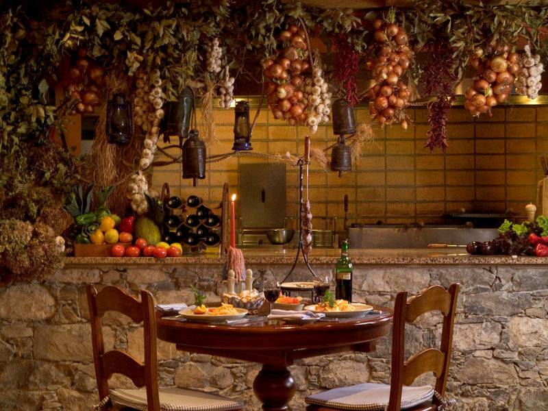 Innenbereich des Pestana Miramar Garden & Ocean Resorts mit gedecktem Tisch und Steinmauer.