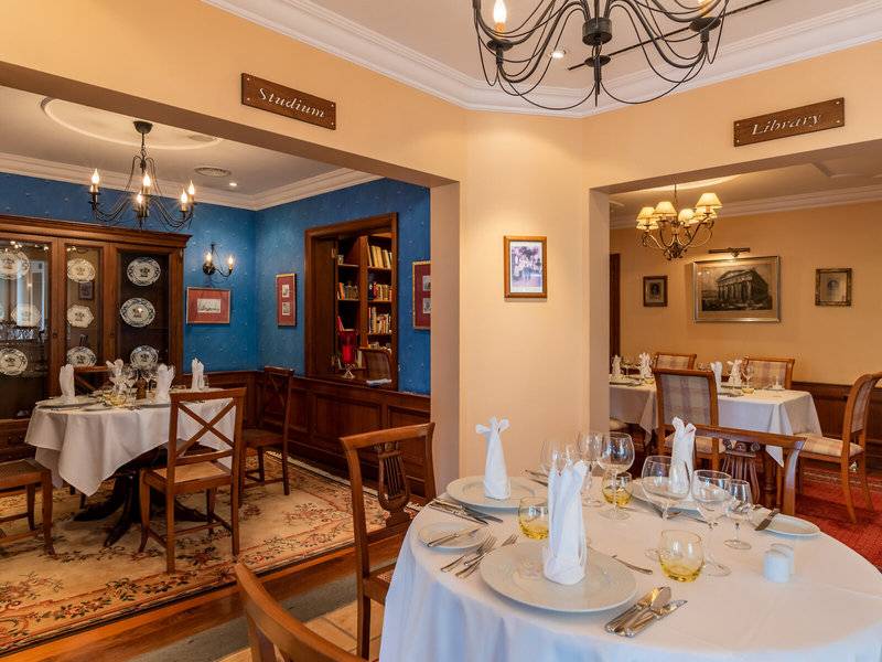 Speisesaal im Pestana Miramar Garden & Ocean Resort mit gedeckten Tischen und eleganter Einrichtung.