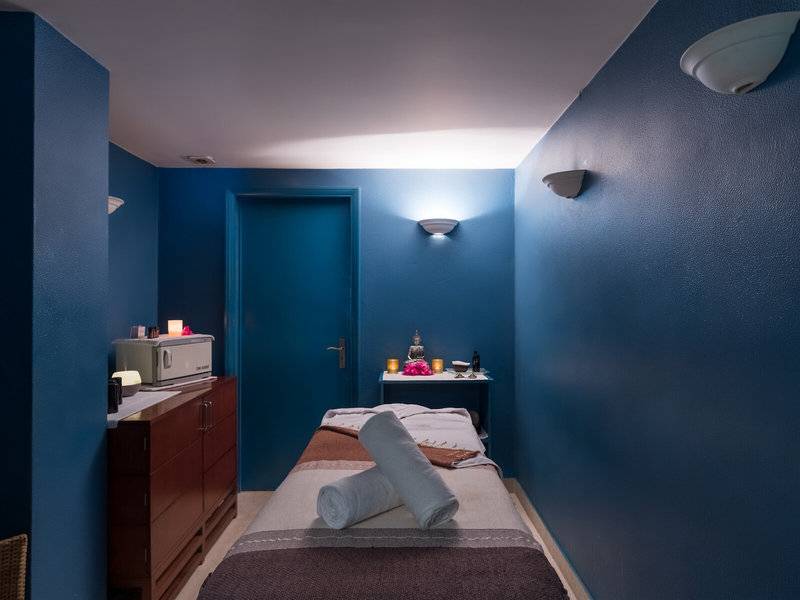 Massageraum im Pestana Miramar Garden & Ocean Resort mit blauen Wänden und einem Behandlungsbett.