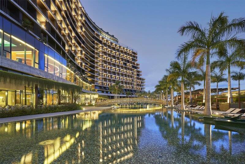 Das Savoy Palace Hotel im Abendlicht mit einem großen Pool und Palmen