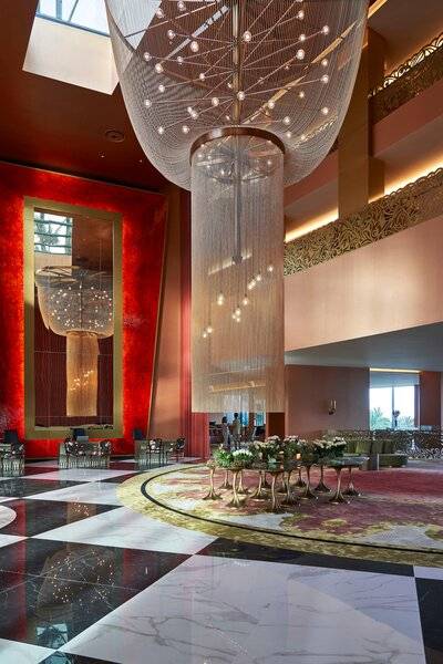 Lobby des Savoy Palace Hotels mit einer großen, leuchtenden Kronleuchter im Mittelpunkt.