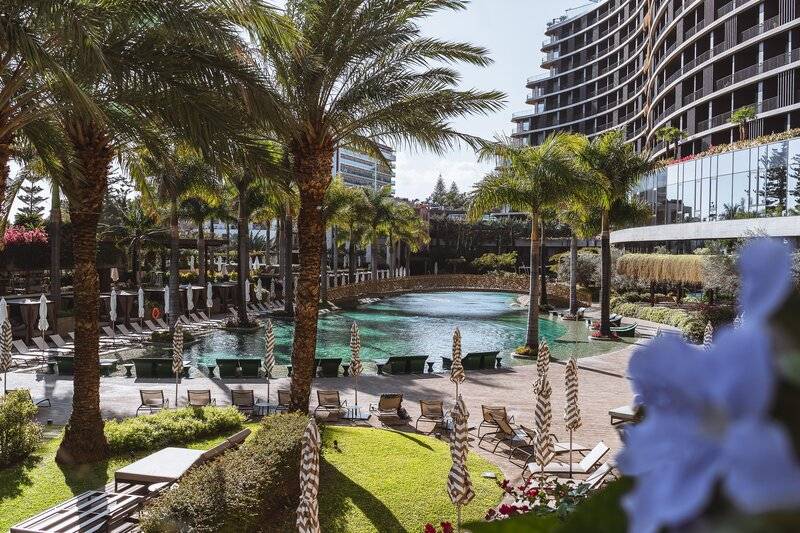 Savoy Palace Hotel mit Swimmingpool und Sonnenliegen im Freien.