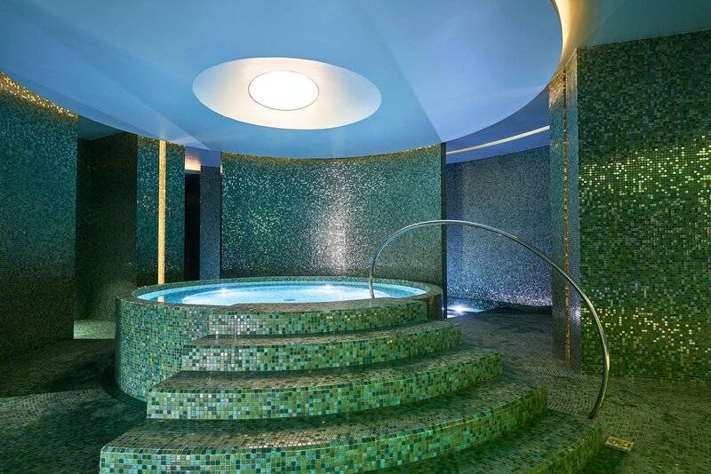 Innenpool des Savoy Palace Hotels mit blauer Decke und grünen Mosaikwänden.