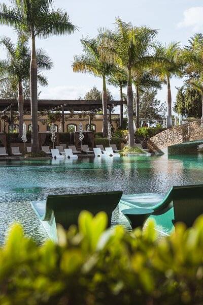 Außenpool des Savoy Palace Hotels mit Loungesesseln und Palmen